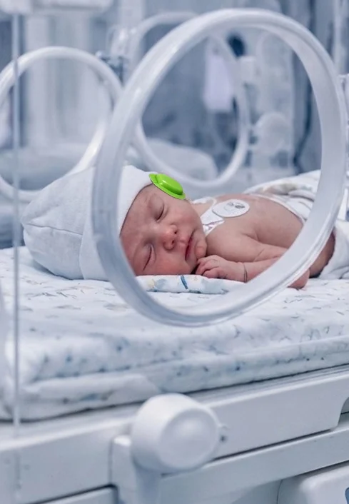 Neonato con protección auditiva Preemie Muffs
